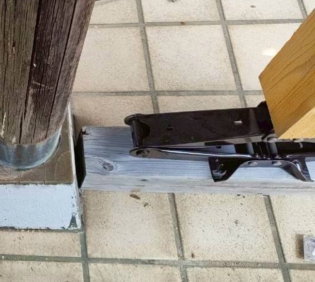 柱をジャッキアップで持ち上げている　ジャッキの下に木材をかませている